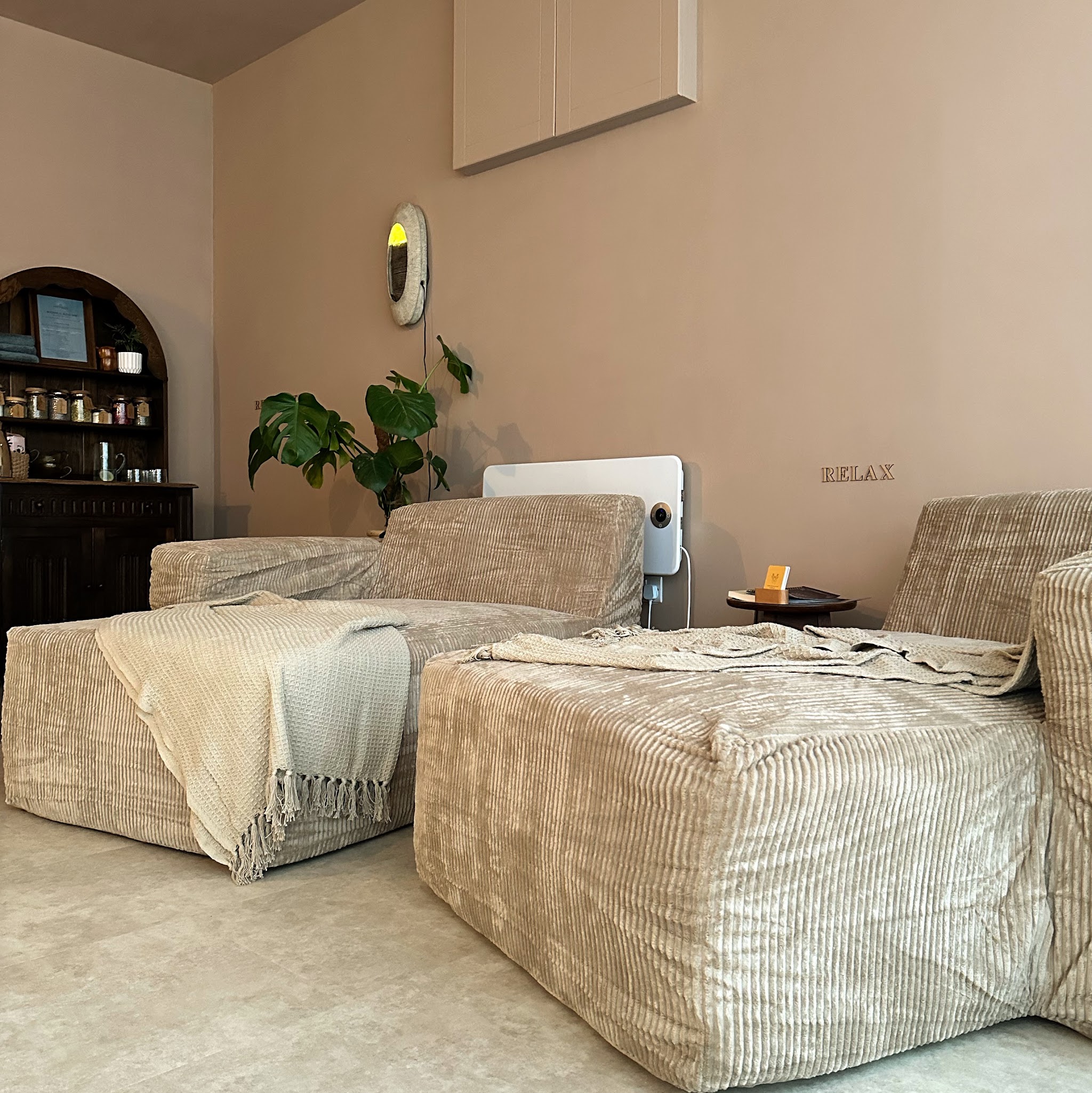 The relaxation lounge: two deep cord loungers with soft throws, a plant and RELAX lettering on the wall