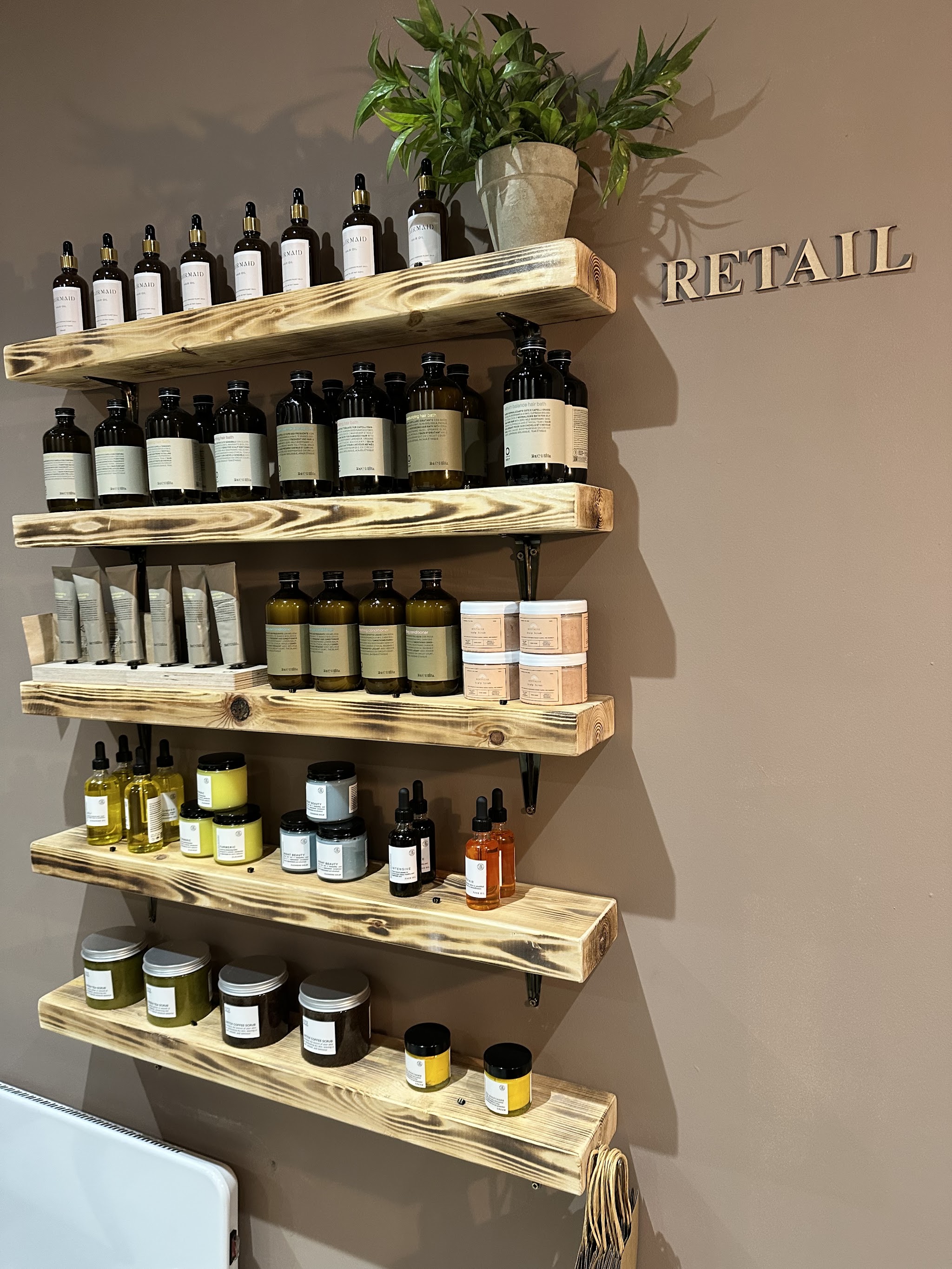 The retail wall: rustic wooden shelves of hair and skin care products under RETAIL lettering